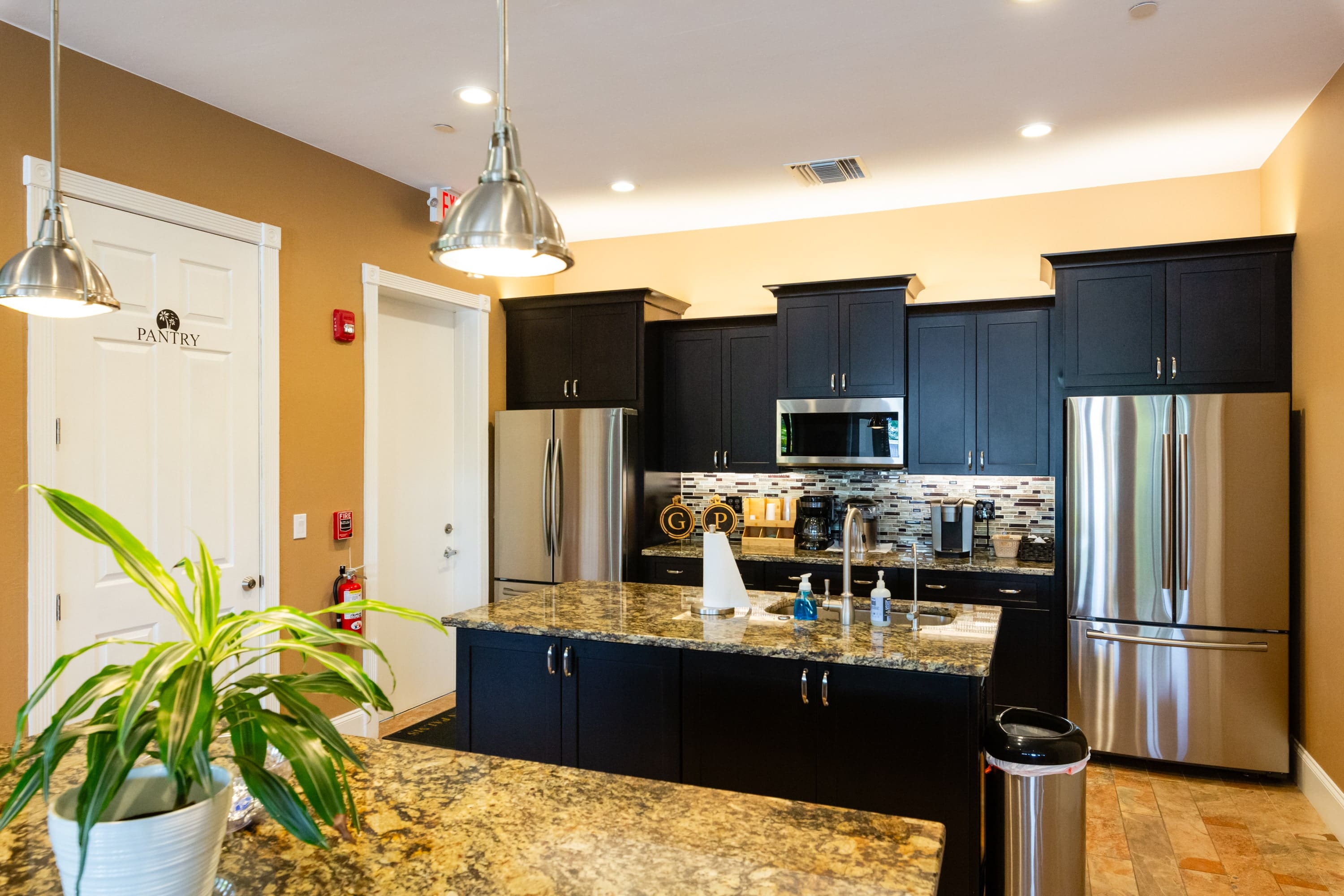 A kitchen with black cabinets and stainless steel appliances.