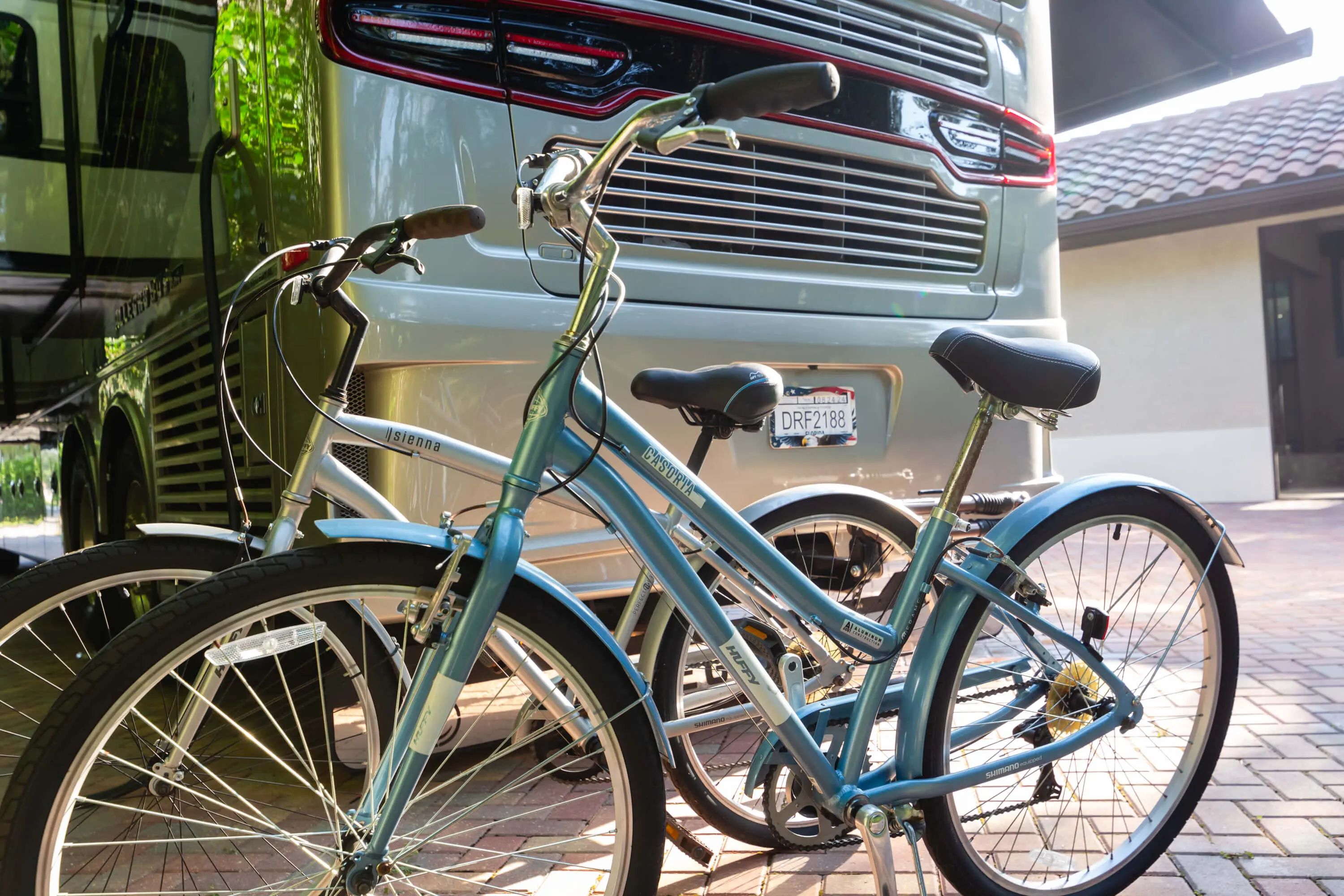 A blue bicycle parked next to a silver van.