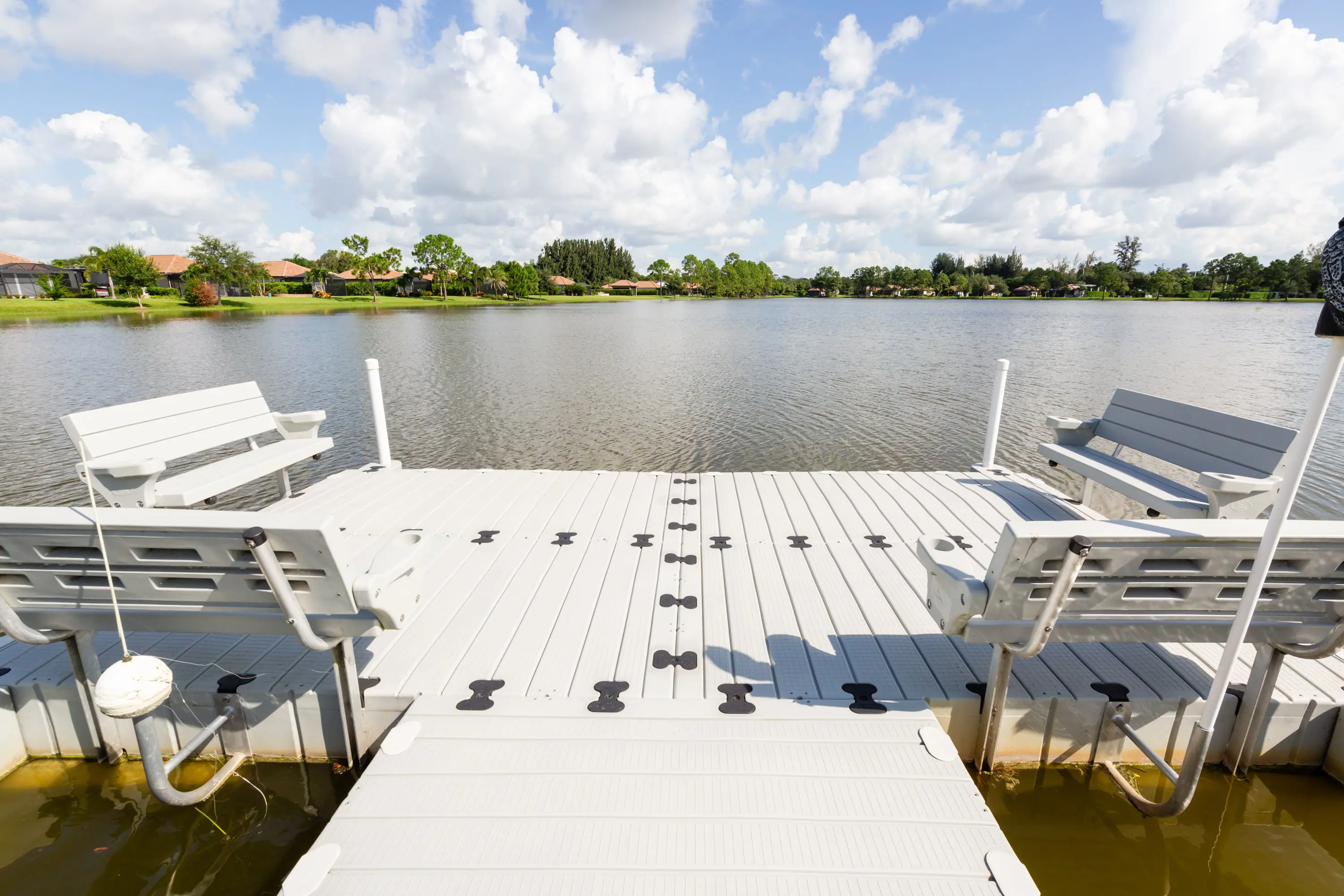 A dock with chairs and a lake in the background.