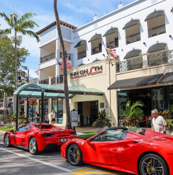 Two red sports cars parked on the side of a street.